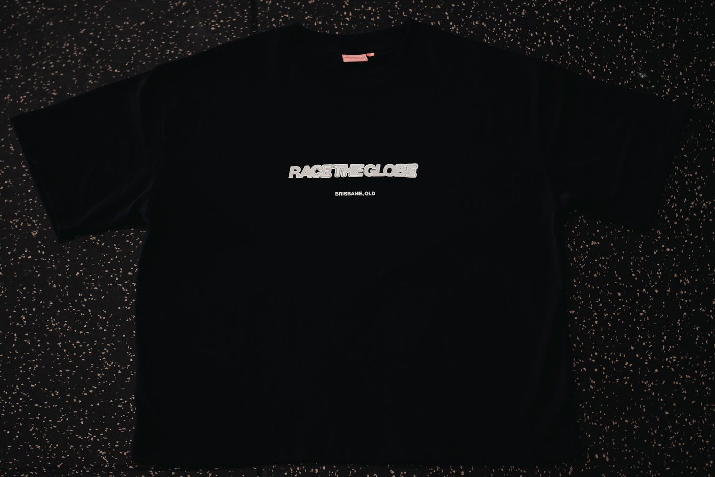 The RTG tee laid flat, front: the Race the Globe mark